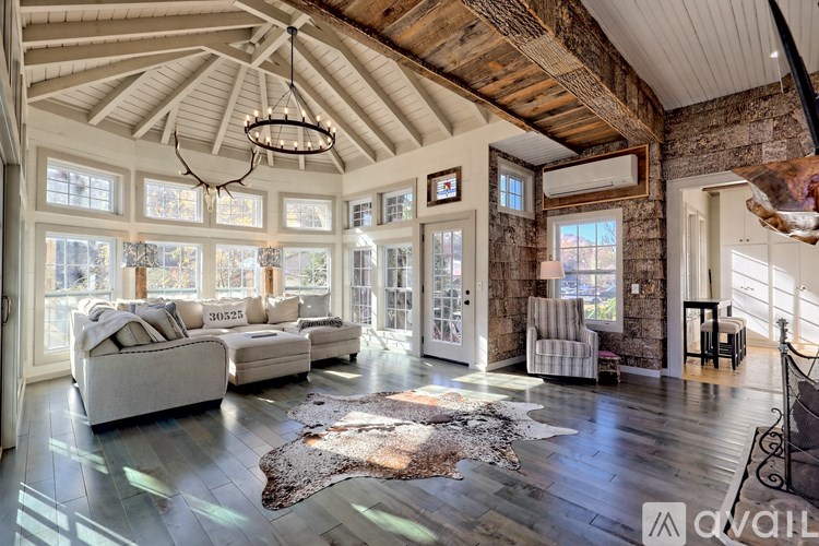 A spacious living room with a high ceiling and large windows.