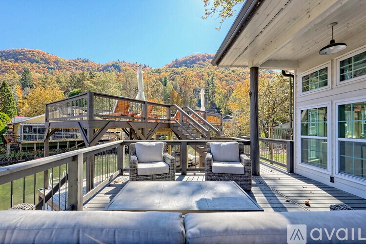 A balcony with two chairs and a table overlooking a mountainous landscape.