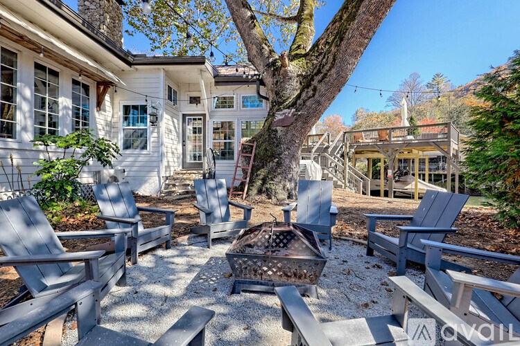 A patio with chairs and a table in front of a house.