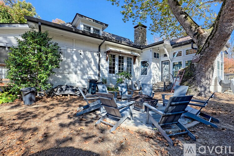 A white house with a tree in front of it.