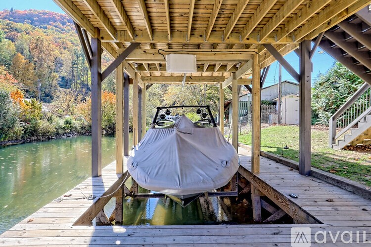A boat is covered and docked at a wooden pier.