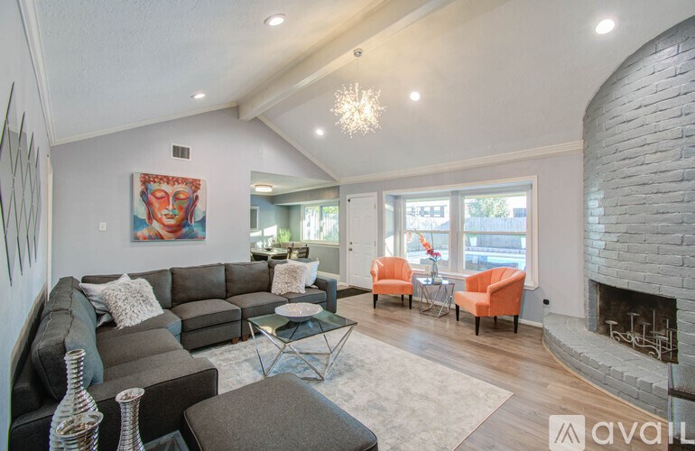 A living room with a grey couch and a fireplace.