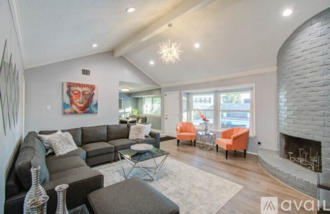 A living room with a grey couch and a fireplace.
