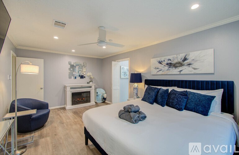 A bedroom with a large bed and a blue chair.