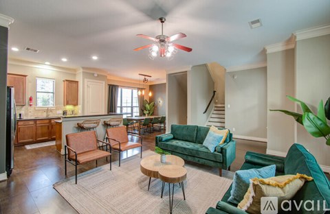 A living room with a green couch and a fan.