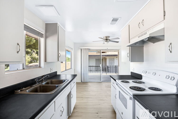 A modern kitchen with a black countertop and white cabinets.