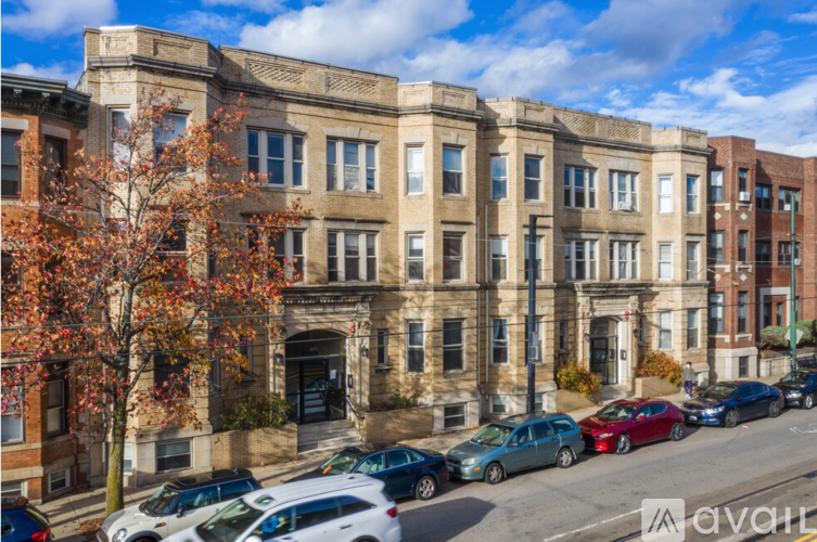 A row of old buildings with cars parked in front.