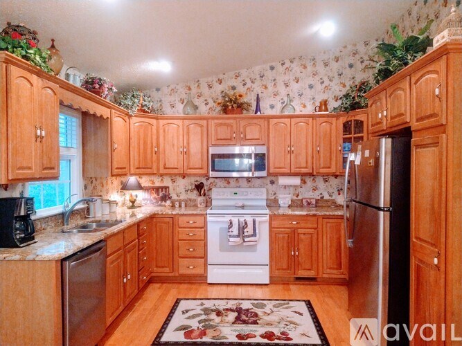 A kitchen with wooden cabinets and a white stove top oven.