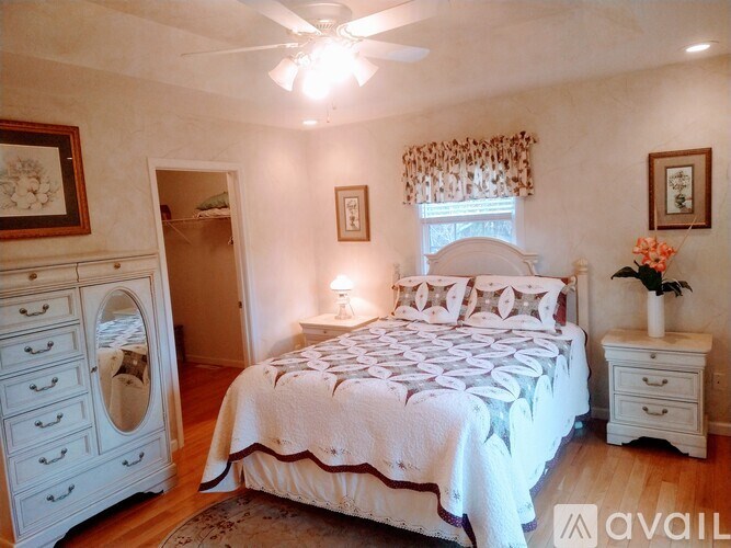 A bedroom with a large bed and a white dresser.
