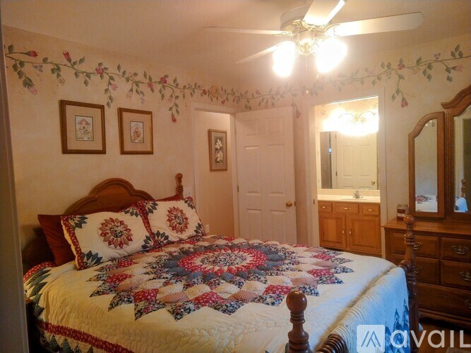A bedroom with a bed, dresser, mirror, and two framed pictures on the wall.