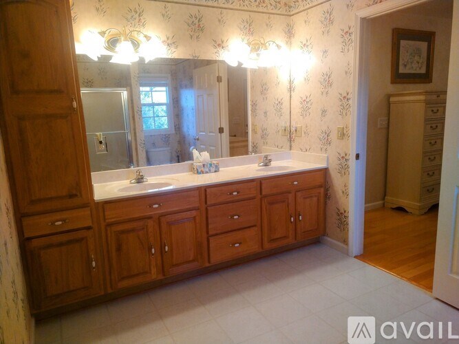 A bathroom with wooden cabinets and a large mirror.