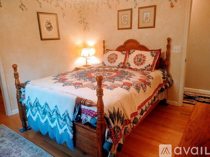 A bed with a wooden frame and a patterned comforter is in the image.