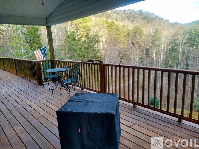A wooden deck with a table and chairs and a flag.