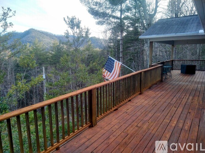 A wooden deck with an American flag hanging on the railing.