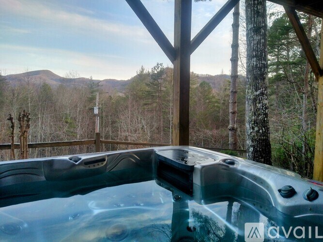 A hot tub is in the foreground with a mountainous landscape in the background.