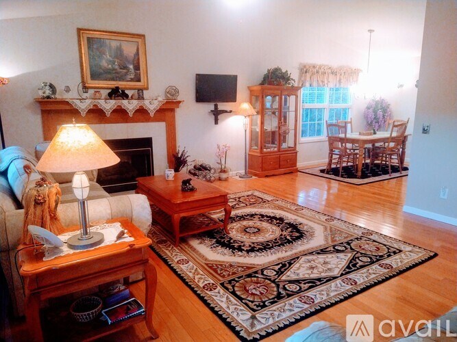 A living room with a fireplace, a sofa, a coffee table, and a rug.