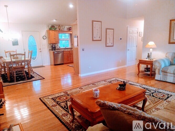 A living room with a wooden floor and furniture.