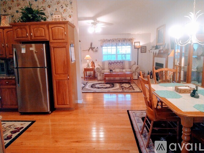 A kitchen with a refrigerator and wooden cabinets.
