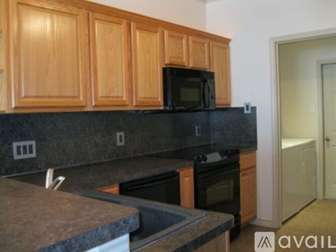 A kitchen with wooden cabinets and black appliances.