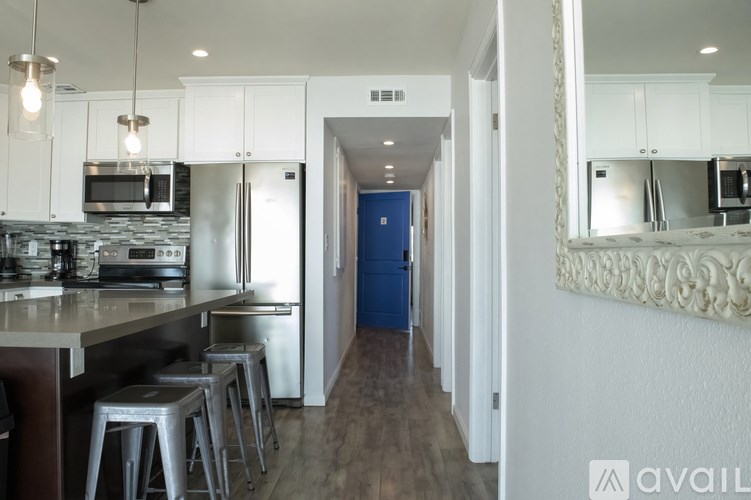 A kitchen with white cabinets and a blue door.