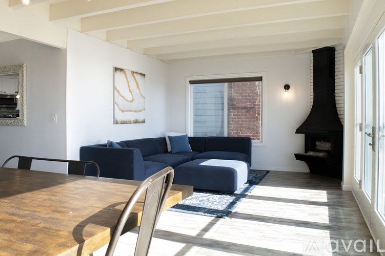 A living room with a blue couch and a wooden table.
