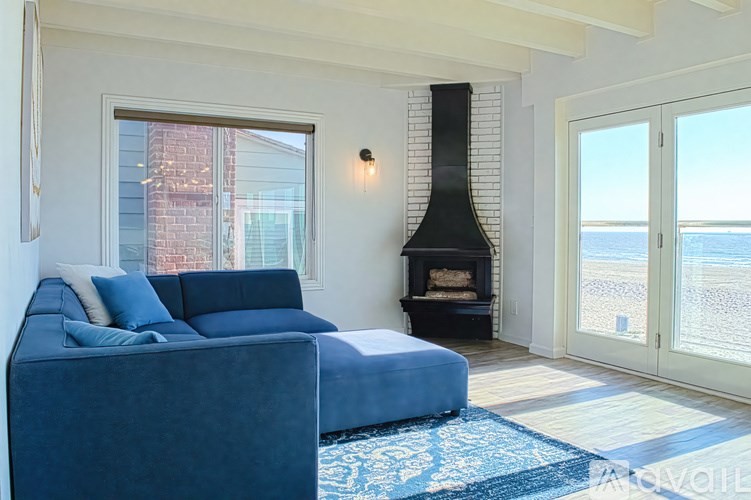 A living room with a blue couch and a fireplace.