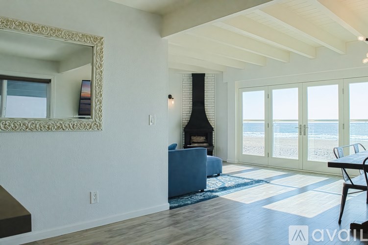 A modern living room with a fireplace and a view of the beach.