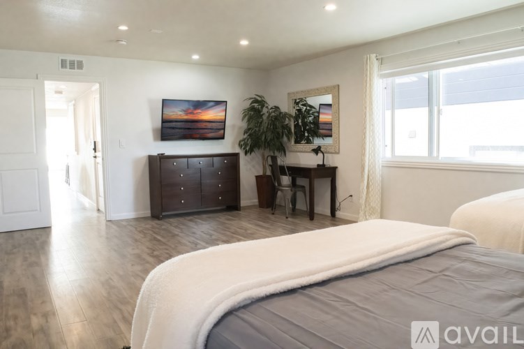 A bedroom with a large bed and a painting on the wall.