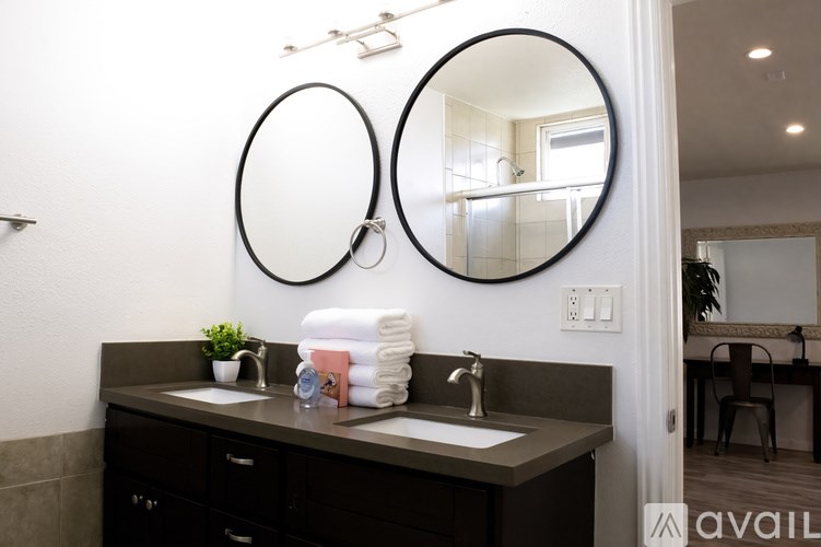 A bathroom with two sinks and two mirrors.