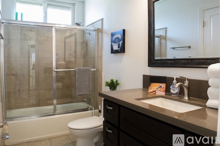 A bathroom with a toilet, sink, and shower.
