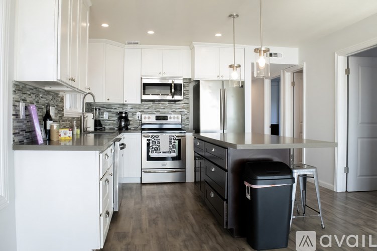 A modern kitchen with white cabinets and stainless steel appliances.
