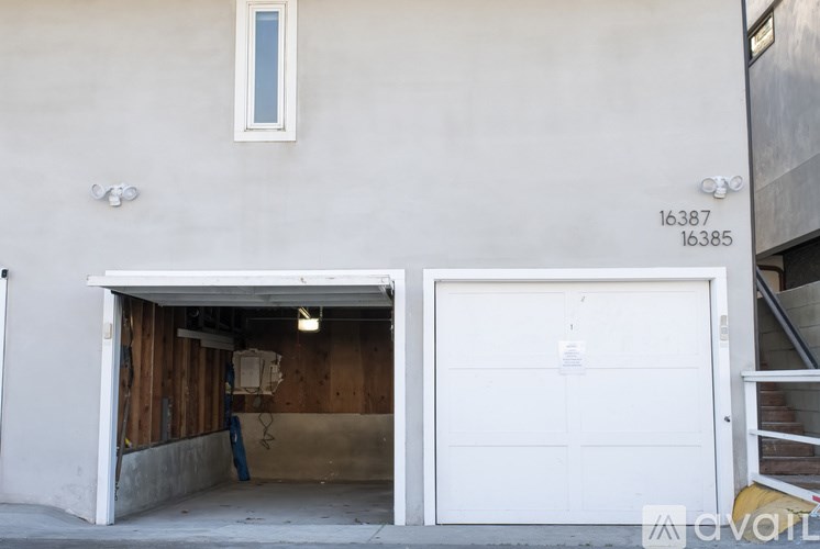 A white garage door is open to reveal a wooden interior.