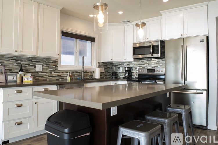 A kitchen with a stone counter top and stainless steel appliances.