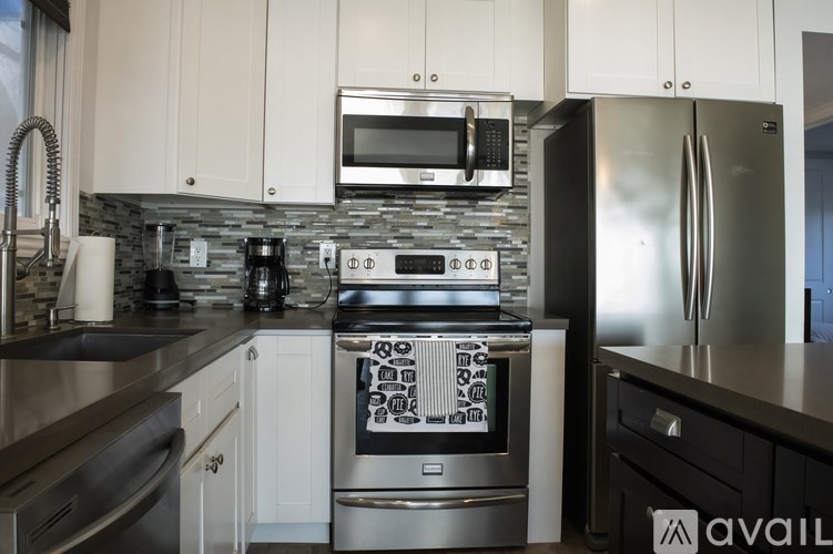 A modern kitchen with stainless steel appliances and white cabinets.
