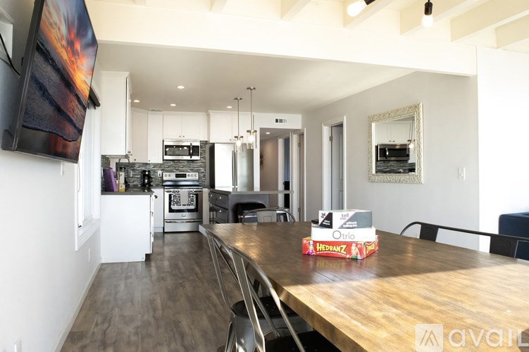 A modern kitchen with a wooden table and chairs in the foreground.