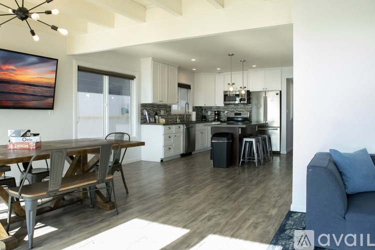 A modern kitchen with a dining table and a couch.