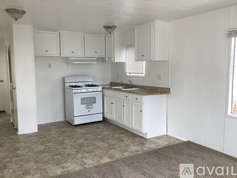 A kitchen with white cabinets and a white oven.
