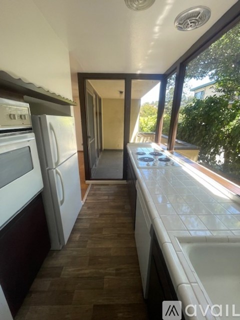 A kitchen with a refrigerator, oven, and sink.