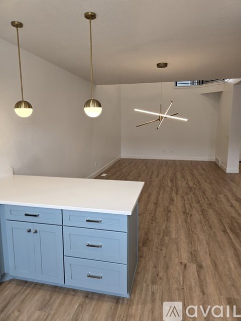 A kitchen with a white counter and blue cabinets.
