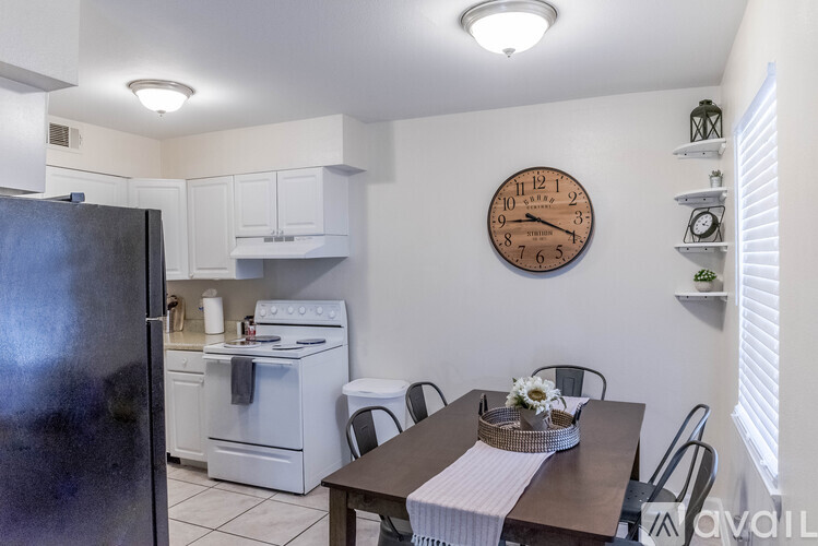 A kitchen with a refrigerator, oven, and dining table.