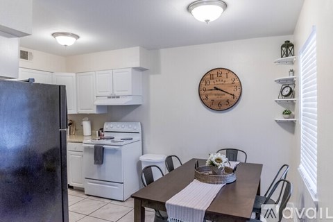 A kitchen with a refrigerator, oven, and dining table.
