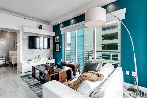 A living room with a white couch and a wooden coffee table.