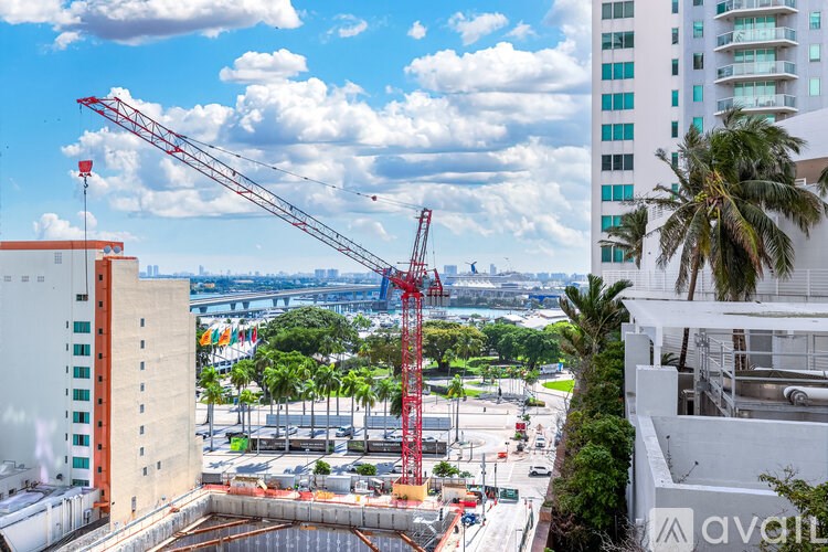 A construction site with a crane and buildings in the background.