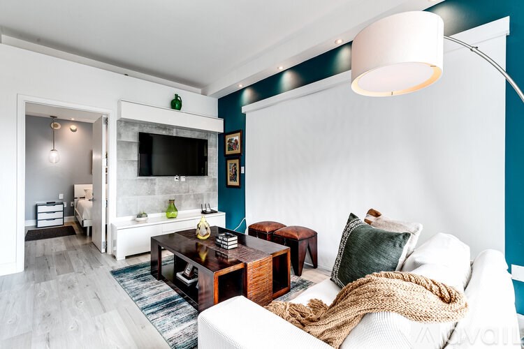 A living room with a white couch and a wooden coffee table.