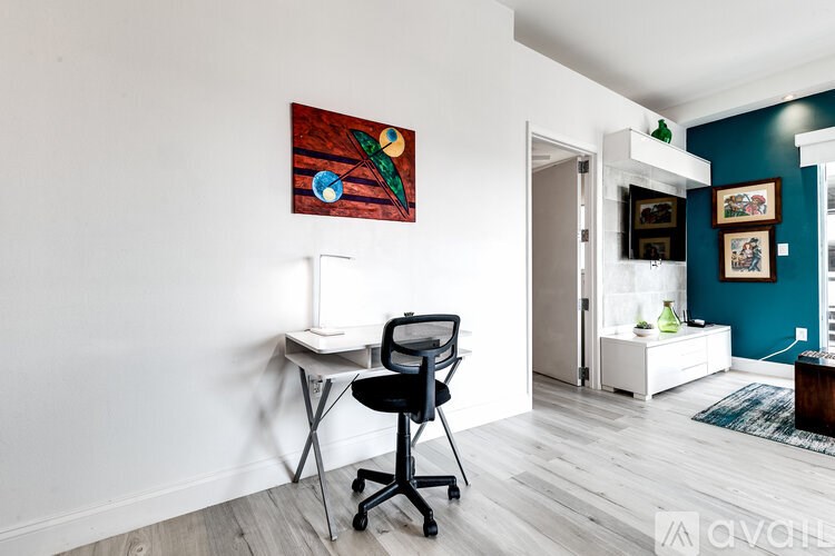 A room with a white desk and a painting on the wall.