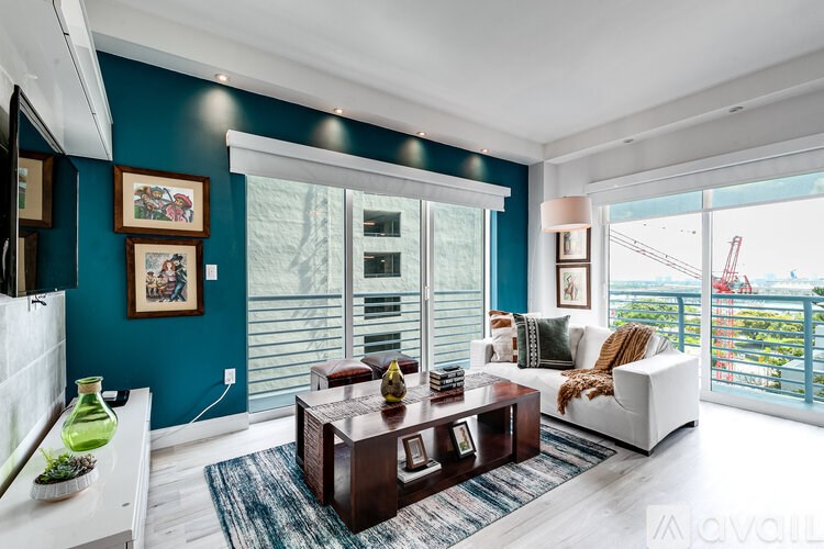 A living room with a white sofa, a wooden coffee table, and a view of the city.