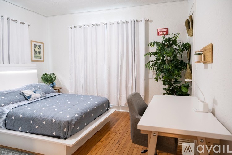 A bedroom with a bed, desk, and chair.