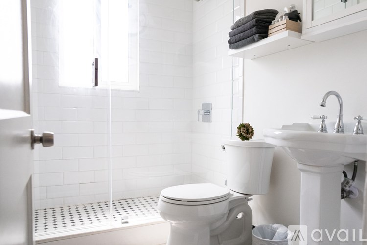 A white toilet sits next to a white sink in a bathroom.