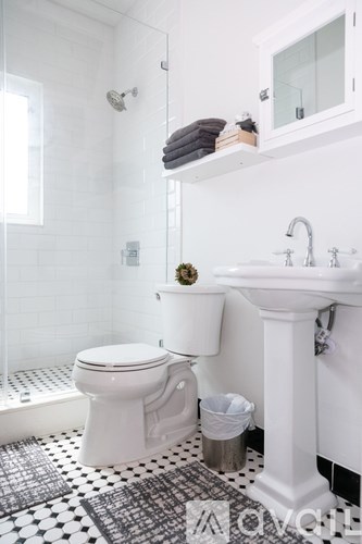 A white toilet sits in a bathroom with a black and white checkered floor.