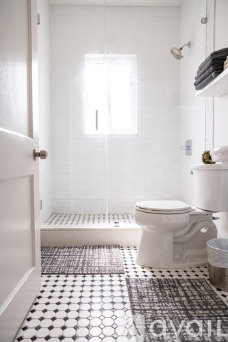 A white toilet in a bathroom with a black and white tiled floor.